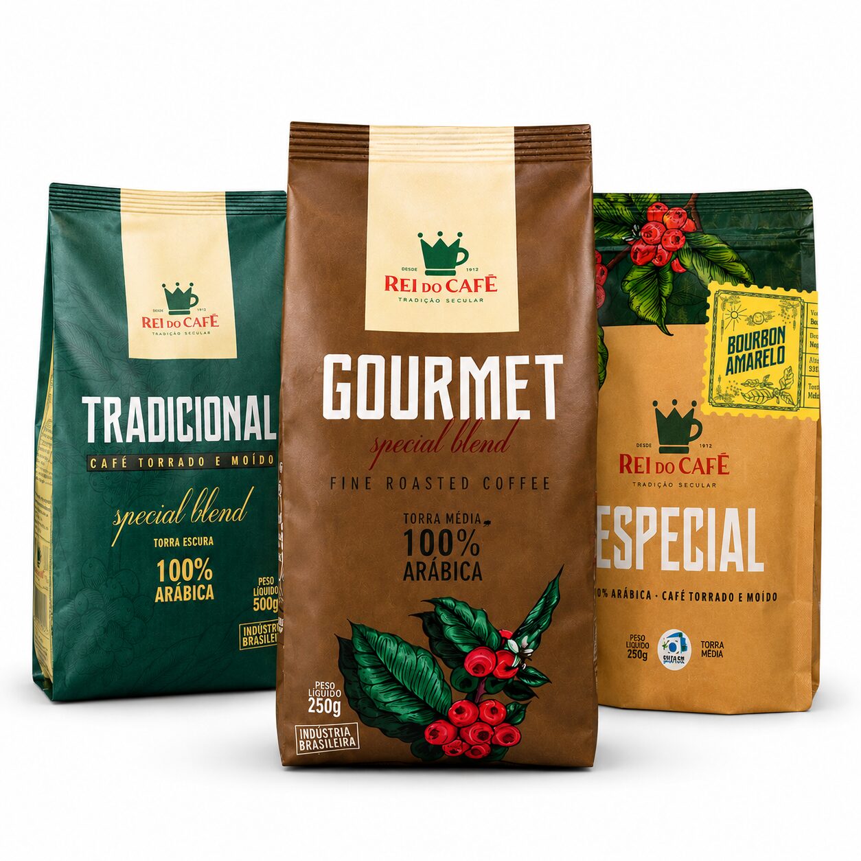 Três pacotes de café Rei do Café lado a lado: Tradicional 500g (embalagem verde, torra escura, 100% arábica, torrado e moído), Gourmet Special Blend 250g (embalagem marrom, torra média, 100% arábica, com ilustração de ramo de café) e Especial Bourbon Amarelo 250g (embalagem kraft, torra média, 100% arábica, torrado e moído)